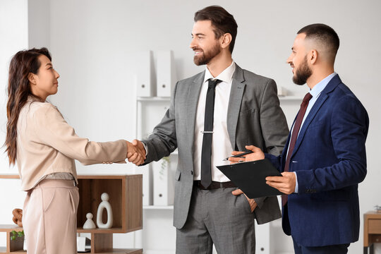 Male court mediator and clients shaking hands in office