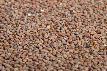 Buckwheat macro texture pattern background, dense repetitive surface in natural brown palette,...