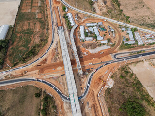The construction site before the construction of the concrete bridge over the intersection by crane workers, tractors, and backhoes