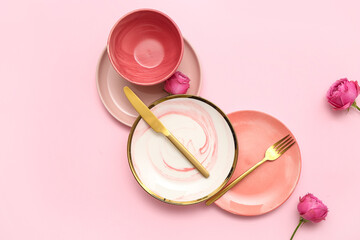 Stylish table setting with beautiful rose flowers on pink background