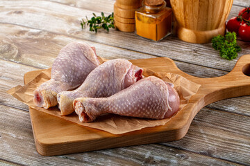 Fresh raw chicken drumstick over board