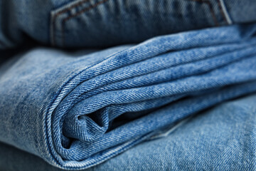 Naklejka premium Stack of different stylish jeans pants as background, closeup
