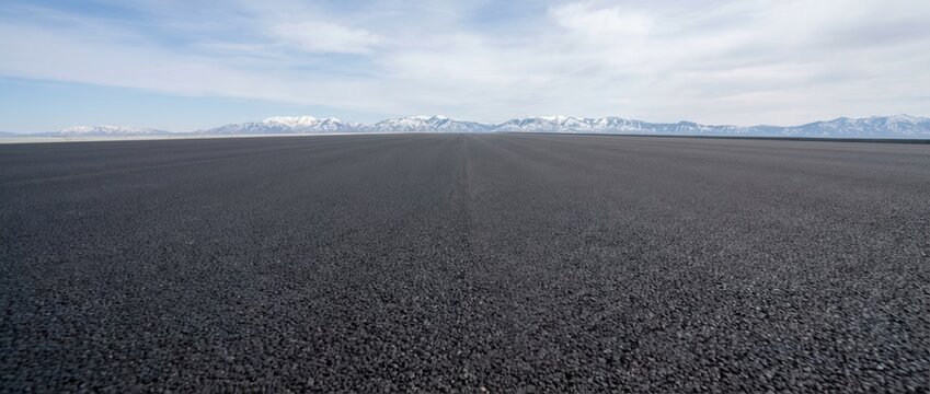 Vast expanse of black volcanic sand beach under a cloudy sky, offering a dramatic natural landscape. - Powered by Adobe