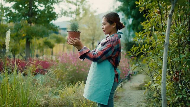 Gardener Holding Potted Plant in Lush Garden
