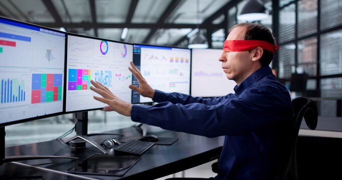 Confused Businessman Blindfolded At Desk