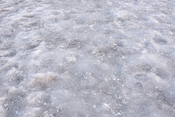 Obraz premium Sidewalk covered with ice in winter. Slippery ice on the sidewalk in winter. Frozen sidewalk dangerous for walking. Close-up. Selective focus.