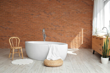 Interior of bathroom with bathtub, chair and sink