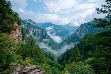 Breathtaking Aerial View of Lush Green Valley Surrounded by Majestic Mountains and Misty Clouds Under a Bright Blue Sky in Nature&rsquo;s Serenity