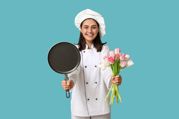 Portrait of young female chef with bouquet of flowers and frying pan on blue background. International Women's Day