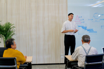 Business class training with a presentor in white shirt present a chart on white board for business training.
