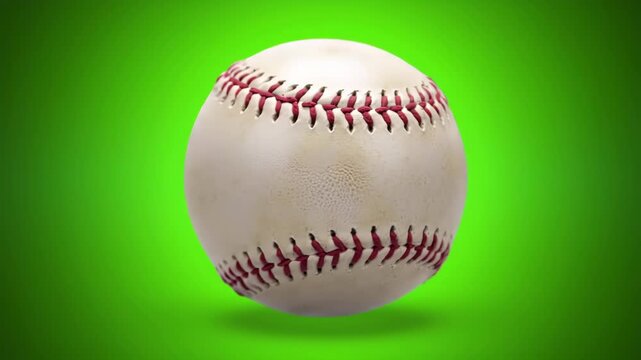 A white baseball with red stitching on green background
