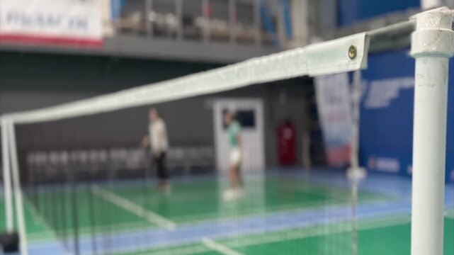 Close detail video frame of badminton net tape with a metal grommet and stitching, highlighting texture, perspective and bokeh background