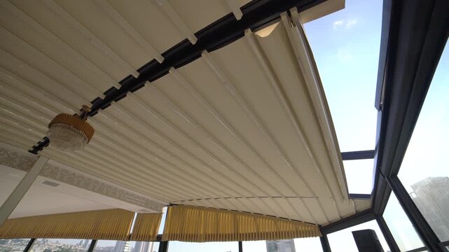 Motorized retractable roof sunshade system opening automatically by remote control design. Flexible outdoor shading solution provides comfort protection and modern architectural appearance.