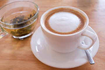 Cappuccino coffee in white cup on wooden table, stock photo