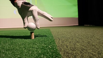 Player prepares to tee off during indoor golf simulation session at training facility