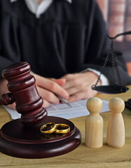 Court session about marriage with rings and figures in front of judge at desk