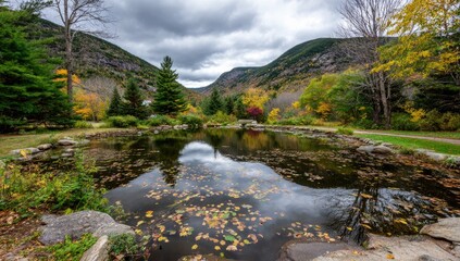 Autumnal pond nestled in a valley, mountains reflected