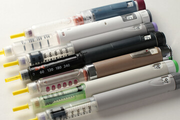 Row of Assorted Insulin Injection Pens on White Background, Close-up of Semaglutide Medication