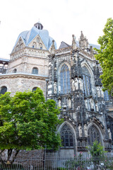Obraz premium Intricate stone carvings and statues on the Gothic exterior of Aachen Cathedral. View of the ornate facade and octagonal dome of the UNESCO World Heritage site
