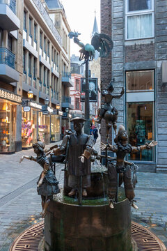 Bronze Puppet Fountain (Puppenbrunnen) in the old town of Aachen, Germany. Iconic landmark featuring movable figures near the Cathedral in a pedestrian zone