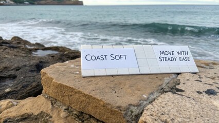 Coastal Scene with Tranquil Waters and Inspirational Signage on Rocky Shoreline Amidst Scenic Natural Landscape