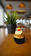 a cupcake on a white plate on a wooden table, breakfast menu in the morning, with natural lighting in the morning