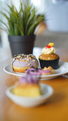 a cupcake on a white plate on a wooden table, breakfast menu in the morning, with natural lighting in the morning