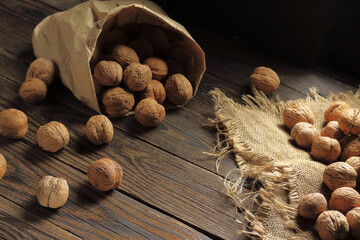 Walnuts Spilling from Paper Bag on Wooden Surface