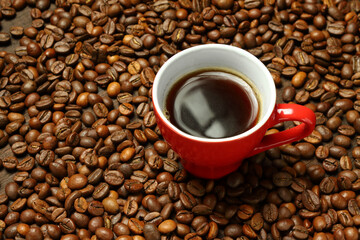 Fototapeta premium Red Mug of Black Coffee on Roasted Beans Bed