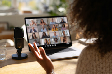Anonymous business woman leading video conference call with professional microphone for e-learning concept.