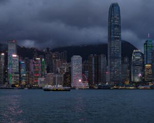 Viewed From Victoria Peak Over Hong Kong Night Skyline With Illuminated Skyscrapers And Dense Cityscape