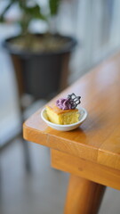 a cupcake on a white plate on a wooden table, breakfast menu in the morning, with natural lighting in the morning