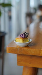 a cupcake on a white plate on a wooden table, breakfast menu in the morning, with natural lighting in the morning