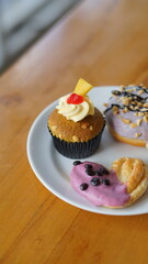 a cupcake on a white plate on a wooden table, breakfast menu in the morning, with natural lighting in the morning