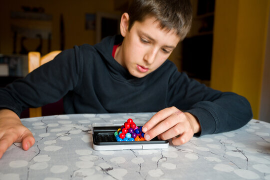 Teenage boy with autism focusing on assembling pieces game. Concept of autism rights movement. World Autism Awareness Day