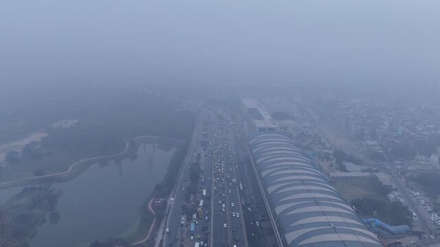 Aerial view of Sarai Kale Khan, Delhi, showing traffic and urban infrastructure under dense smog and poor air quality