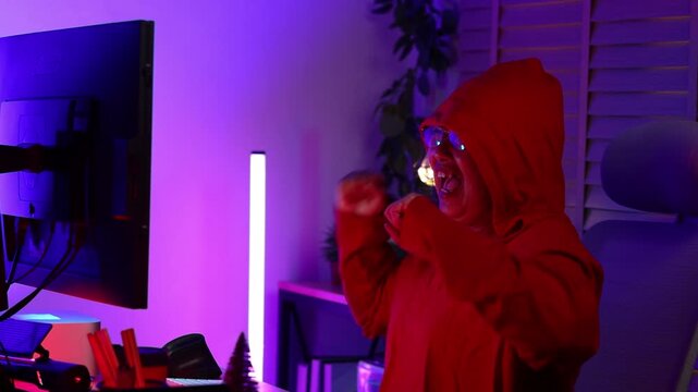 cyber crime. Senior woman hacker hacking computer. anonymous hacker wearing black hoodie in dark room. online scam and cyber security threat.