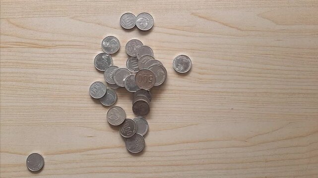Coins scattered on a wooden table background