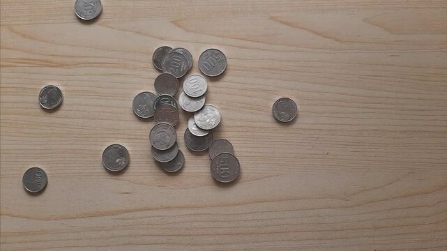 Coins scattered on a wooden table background
