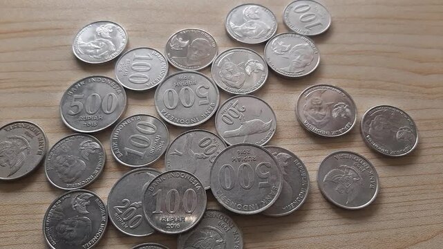 Coins scattered on a wooden table background
