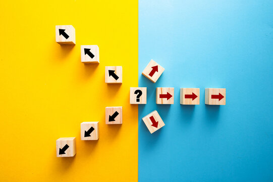 Wooden cubes with arrows showing decision uncertainty and different directions