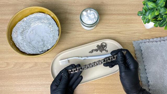 Cleaning a silver chain at home using simple products. A concept for jewelry care, savings, DIY maintenance, and a practical lifestyle.