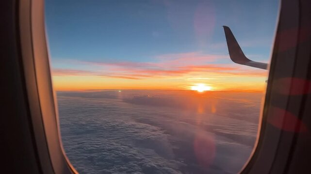Stunning sunrise view from an airplane window over a sea of clouds with winglet visible