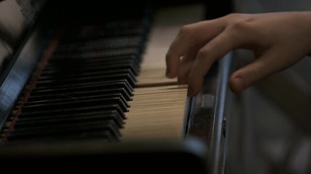 Cinematic close up of a teenager&rsquo;s hands playing the piano at home, captured in a vintage style as one continuous emotional scene focused on learning. The camera stays close to the keyboard