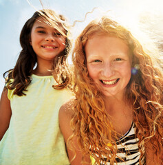 Fototapeta premium Portrait, happy girl and children outdoor with friendship for summer holiday, fun and bonding together. Low angle, kids and smile with sunshine for vacation, playing or childhood memories on weekend.