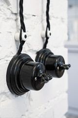 Vintage style ceramic black light switch on the white brick wall. 
