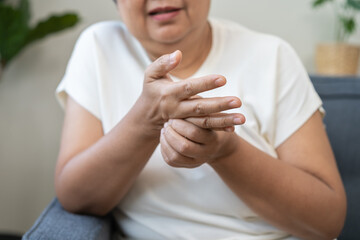 Health care concept, rheumatism asian senior woman hand pain from cramp, trigger finger, wrist pain...