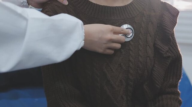 Lovely young latina doctor using stethoscope to examine senior patients vitals. Charming hispanic doctor using medical instrument to check heart and lungs of female caucasian senior patient