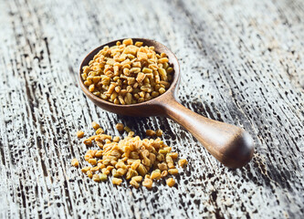 Fenugreek seeds on wooden background