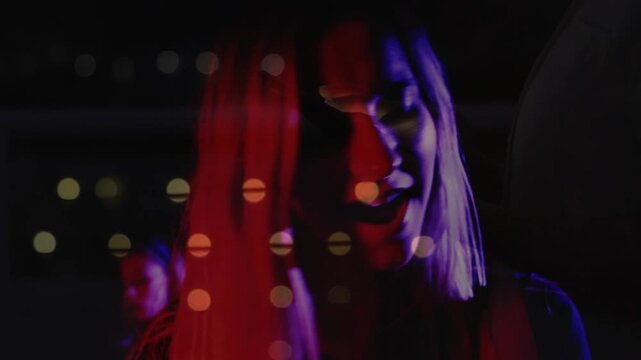 Blonde woman tilting and singing in music shoot dotted overlay and colored gels causing head turns